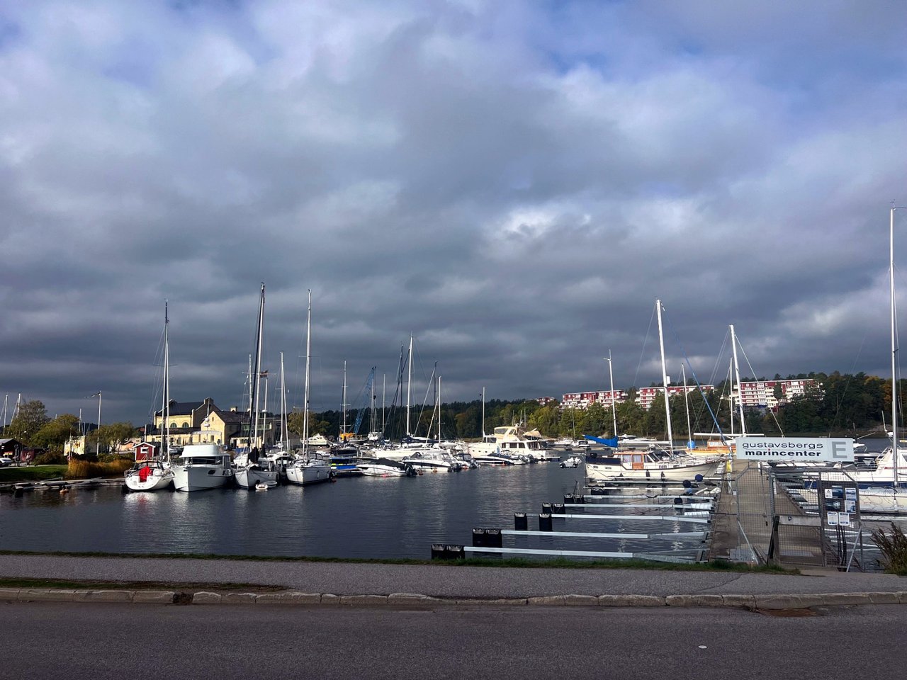 Gustavsberg harbour with boats at the jetties and older factory buildings along the water